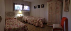 a hotel room with two beds and a window at Sardegna Beach Cala Reale in Santa Marinella