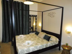 a bedroom with a black canopy bed with a mirror at Rio Groppo Guesthouse in Manarola