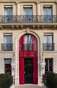 um edifício com uma cortina vermelha sobre uma porta em La Réserve Paris Hotel & Spa em Paris