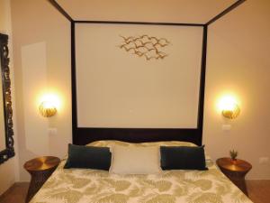 a bedroom with a bed with a black headboard and two tables at Rio Groppo Guesthouse in Manarola
