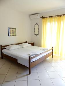 a bedroom with a large bed with white sheets at Apartmani Villa Jasminka in Podgora