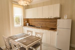 a kitchen with a table and a white refrigerator at Antique Residence in Hisarya