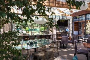 a restaurant with a glass table and chairs at Hotel Boutique Unico Avandaro in Valle de Bravo