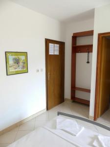a room with a bed and a wooden door at Apartmani Villa Jasminka in Podgora +20 photos