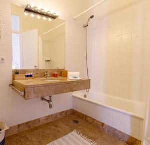 Un baño con lavabo, bañera y espejo. en Alcacer River Apartment, en Alcácer do Sal 47 fotos más