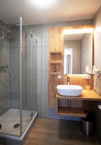 a bathroom with a sink and a shower at Hotel & Gutsgasthaus Köberle in Lindau
