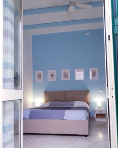 um quarto com uma cama com uma parede azul em Mondello Home "46 passi" em Palermo