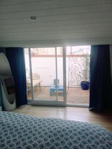 Schlafzimmer mit einem Bett und Blick auf einen Balkon in der Unterkunft Duplex Denim in Nîmes