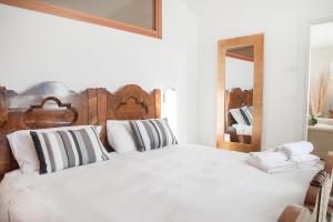 a bedroom with a large white bed with a wooden headboard at Casa Calvola holiday home in Tenno