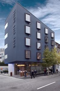 a black building with people walking in front of it at Blue City Boutique Hotel in Baden