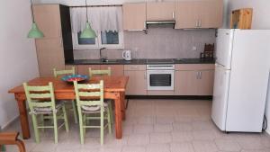 a kitchen with a wooden table and a white refrigerator at Anemos Seaside House in Skiros +19 photos