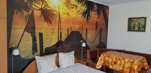 a bedroom with a mural of a pier and palm trees at Apartament Belvedere in Olimp