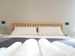 une chambre avec un lit avec des draps blancs et des oreillers dans l'établissement LAB3 City Private Apartment - 2 Bedrooms, à Pavia 21 autres photos