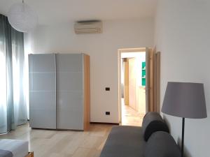 a living room with a couch and a refrigerator at LAB3 City Private Apartment - 2 Bedrooms in Pavia