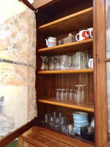 ein Holzschrank mit vielen Gläsern in der Unterkunft la maison perchée in Le Vast