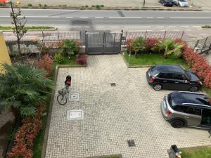 uma pessoa numa bicicleta num parque de estacionamento com dois carros em Relais fiera milano em Pero