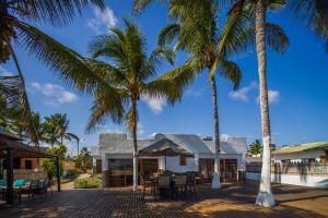 a house with palm trees in front of it at Isamar Hotel in Puerto Villamil
