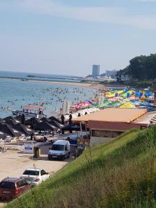 a beach with a bunch of people in the water at Apartament Belvedere in Olimp