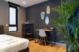 a bedroom with a bed and a desk and a plant at Boutique Suites Lisse - Schiphol in Lisse