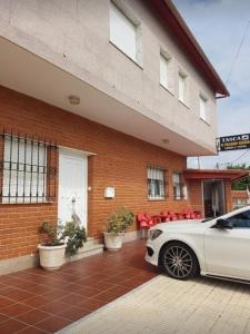 a white car parked in front of a building at Pension Paxaro Negro in Sanxenxo
