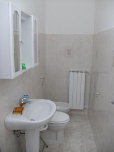 Baño blanco con aseo y lavamanos en Antico Borgo, en Roseto degli Abruzzi