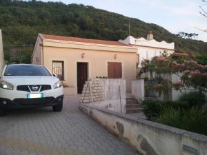 une voiture blanche garée devant une maison dans l'établissement DOMUS AUSTRI, à Messina