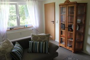 een woonkamer met een bank en een boekenplank bij Ferienwohnung Schmahl in Schleiden
