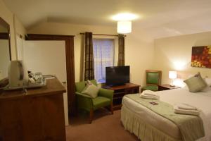 une chambre d'hôtel avec un lit et une télévision dans l'établissement Castle Lodge, à Ely