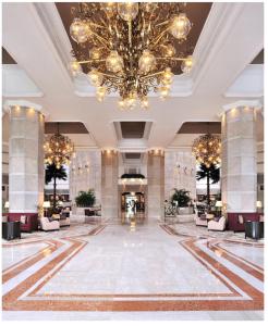 un'ampia hall con un grande lampadario a braccio di Taj Bengal a Calcutta