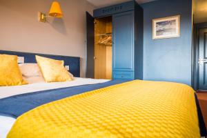 a bed in a bedroom with a blue wall at THE DONARD in Newcastle