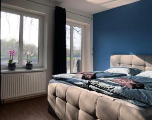 Un dormitorio con una cama y una pared azul. en Ferienwohnung Schleusenhaus Hameln, en Hameln