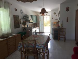 a kitchen with a table and chairs and a dining room at Villetta immersa nel verde ma vicina al mare in Lascari