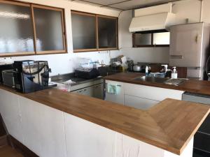 a kitchen with a wooden counter top at Megijima Island Guesthouse & cafe Megino in Takamatsu