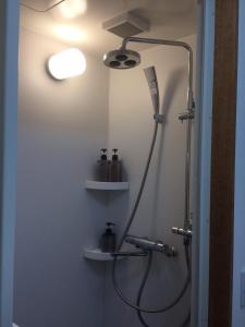 a bathroom with a shower with a light on the wall at Megijima Island Guesthouse & cafe Megino in Takamatsu