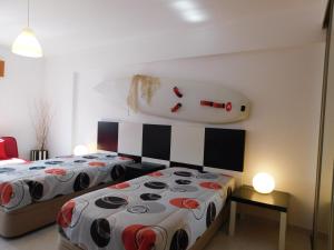 a bedroom with two beds and a large head on the wall at Tropical Rocha Residence in Portimão