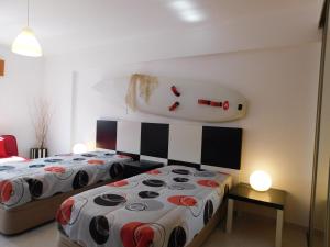 - une chambre avec 2 lits et une grande tête sur le mur dans l'établissement Tropical Rocha Residence, à Portimão