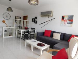ein Wohnzimmer mit einem Sofa und einem Tisch in der Unterkunft Tropical Rocha Residence in Portimão