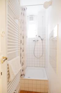 ein weißes Bad mit einer Dusche und einer Badewanne in der Unterkunft Privatzimmer in bester Altstadtlage in Tübingen