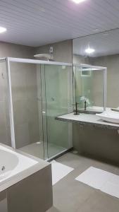 y baño con ducha acristalada y lavamanos. en Pousada das Bromélias, en Porto de Galinhas