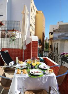 a table with plates of food on a balcony at Casa Isa in Valencia