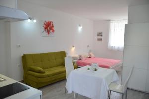 a room with a bed and a couch and a table at Downtown Sweet Studio in Novalja