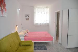 a room with a bed and a couch and a window at Downtown Sweet Studio in Novalja