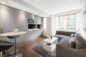 a living room with a couch and a table at Beautiful Chelsea Apartment in Fashion District in London