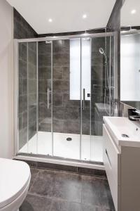 e bagno con doccia, servizi igienici e lavandino. di Beautiful Chelsea Apartment in Fashion District a Londra