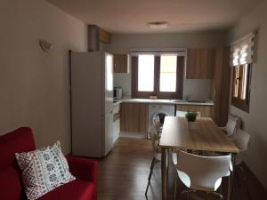 una pequeña cocina con mesa y nevera en Apartamentos La Solana, en Potes