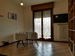 ein Esszimmer mit einem Tisch, Stühlen und einem Fenster in der Unterkunft Horus apartment in Padua
