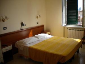 1 dormitorio con 1 cama grande con manta amarilla en Serafino Liguria Hotel, en Génova