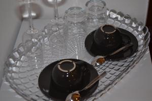 a glass plate with two black dishes and wine glasses at Rio Groppo Guesthouse in Manarola