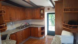 una cocina con armarios de madera y fregadero en Finca El Manzano, en Cortegana