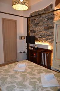 a bedroom with a bed and a stone wall at Rio Groppo Guesthouse in Manarola